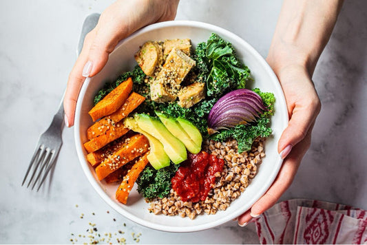 A vegan-friendly meal in a bowl filled with various grains and vegetables.