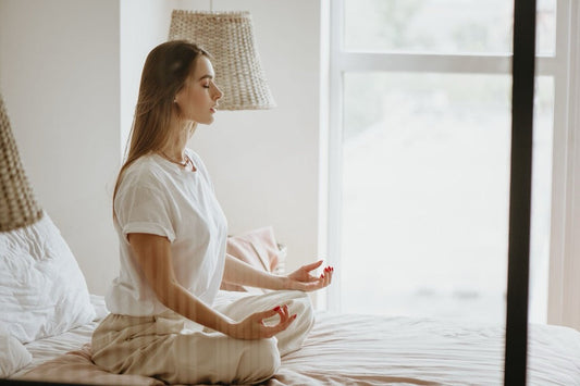 A woman meditating indoors.