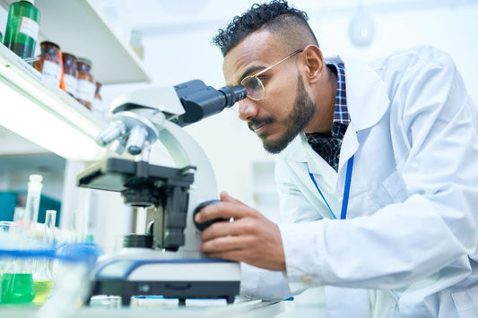 A scientist working in a lab with a microscope.